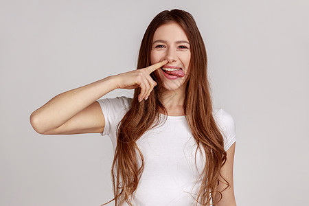 有趣的女人挑鼻子 用愚蠢的傻脸 拉出鼻孔 不良的举止 行为失检图片