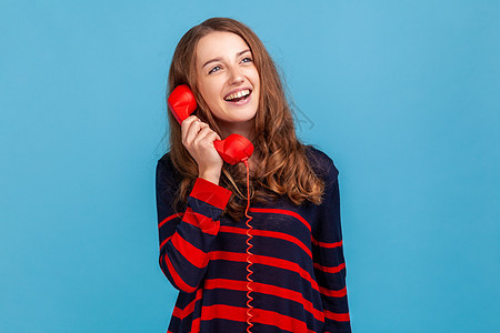 女人通过红色的反向地线电话说话 聊天愉快 笑着看不开图片