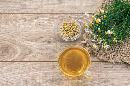 一杯绿色茶 有白甘菊花 在木制背景上玻璃早餐洋甘菊母菊饮食草本植物杯子食物药品植物图片