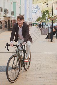 在城市骑自行车的成年男子商业潮人工人人士男性生态乐趣天气运输环境图片