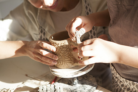 陶瓷制作母亲和生子制造波特家庭创造力艺术孩子黏土装潢工艺邮票父母女士背景