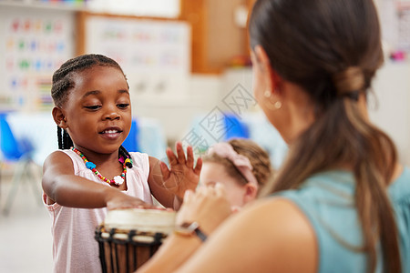 握持和操纵仪器是极好的精细运动技能练习 一个女人在课堂上教孩子乐器图片