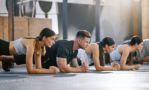 在健身房里 一群健康的人一起做体重平板支撑运动 专注于运动员训练以增强肌肉 增强上半身 加强核心并增加健身课锻炼的耐力图片
