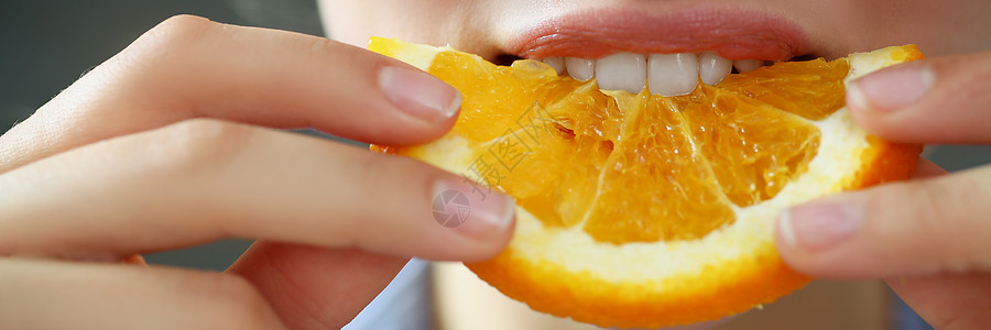 妇女手手里握着切片的橙子食物 在厨房用嘴吃早餐收成裁剪烹饪厨师手指牙齿饥饿鼻子宏观女性图片