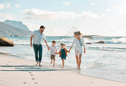 白人家庭手牵着手在海滩上享受有趣的暑假 慈爱的父母与他们嬉戏无忧无虑的小儿子和女儿在沙滩上赤脚走来走去图片