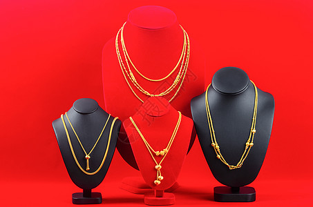 皮瑟利和金首饰项链展出站在红色天鹅绒织物上的金项链上图片