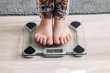站在秤上测量体重的女孩的腿 家里有体重秤的白人女性赤脚 检查秤上重量的人 节食 控制和测量图片