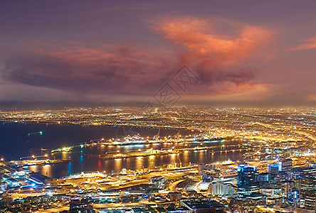 从南非信号山看开普敦夜景 在黑暗多云的傍晚天空下 城市灯光和建筑物的美丽景观 暮色中的热门旅游小镇背景图片