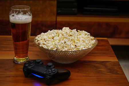 喝啤酒碗爆米花和木制背景家庭娱乐的游戏板图片