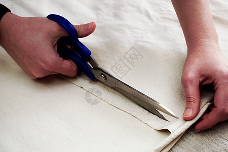 妇女在家里测量和切割织布 近视织物剪裁针线活剪刀手工夹子缝纫工具白色配件图片