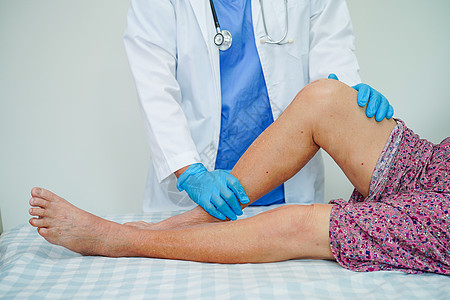医生检查在医院内接受伤疤膝盖替换手术的亚洲老年妇女患者的情况治疗疼痛愈合身体病人药品纤维主食肌腱外科图片