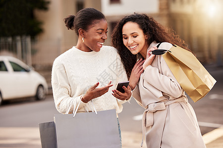 新店警讯 两名年轻女性使用智能手机 在城市背景下买东西时使用智能手机图片