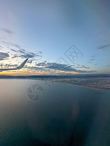 从一架飞机的窗口看到云和天空 从飞机的窗户看照明器玻璃太阳日落机器蓝色客机航空旅行土地图片