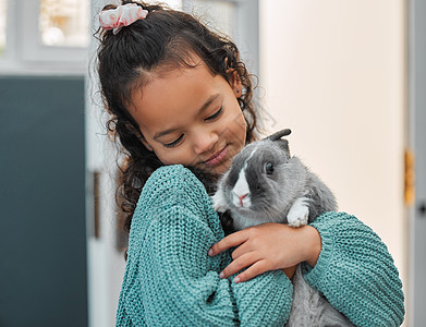 你好 兔子先生 一个可爱的小女孩 在家和她的宠物兔子亲热背景