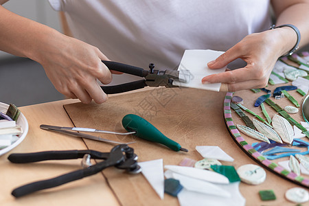 马赛克大师的工作场所 女性在制作马赛克过程中手持马赛克细节工具玻璃白色陶瓷爱好女孩围裙工作室制品艺术框架图片