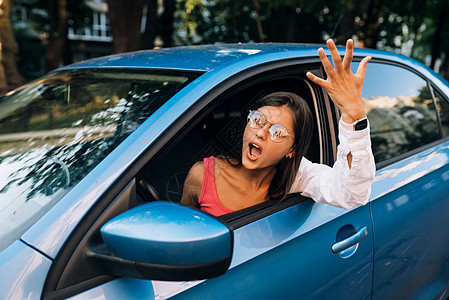 一个愤怒的年轻女人从车窗外偷看司机旅行技术土地窗户女性速度快乐享受太阳图片
