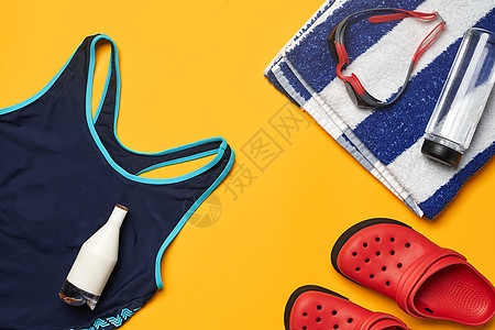黄色背景的平整夏日泳池配件 多色沙滩游泳衣娱乐锻炼活动泳装毛巾行李袋套装训练女性图片