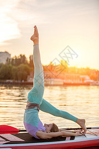 运动型女性在桨板上做瑜伽 在垫板上做瑜伽 锻炼灵活性和伸展肌肉太阳福利自由假期海滩晚饭生活方式运动情绪城市图片