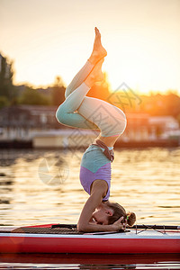 运动型女性在桨板上做瑜伽 在垫板上做瑜伽 锻炼灵活性和伸展肌肉活动城市生活方式姿势成人假期自由太阳情绪旅行图片