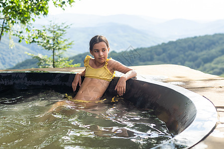 夏天 在山里的热水浴缸里的小姑娘女性成人森林卫生保健温泉增值税照片空气洗澡图片