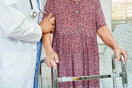 医生帮助亚洲老年妇女残疾病人在护理医院与行尸一起行走 医疗概念是好的长老卫生康复护士母亲祖母护理保健机动性学习图片