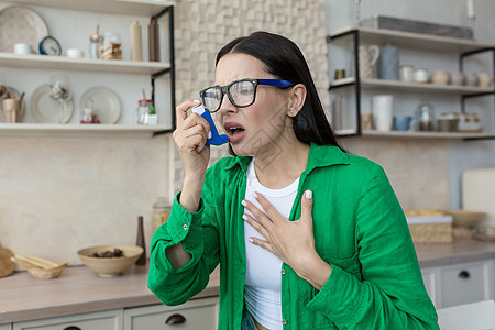 家中患有哮喘病的年轻患病妇女 使用吸入器呼吸放松呼吸图片