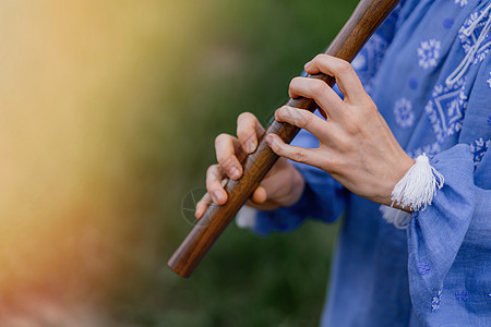 女人在户外演奏木管乐器木笛乌克兰 sopilka 民间音乐 文化概念 乐器 身穿传统刺绣衬衫的女士  蓝色 vyshyvanka图片