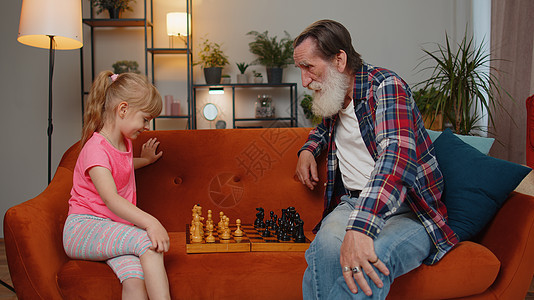 微笑的老爷爷玩棋盘游戏 在家和十几岁的孙女女女儿孩子一起玩两个人男人青春期客厅祖父母孙辈思维挑战竞赛娱乐图片