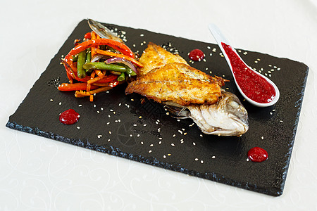 鱼沙拉饭馆的美味食物 盘子上烧烤餐厅木头菜单叶子牛肉石板宏观胡椒玻璃背景