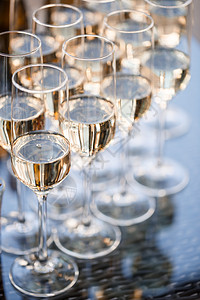 装满鲜香香槟并站在桌上的玻璃杯瓶子厨房宴会餐厅金子水晶高脚杯婚礼液体食物商业背景图片