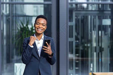 美丽和快乐的女人与短头发的非洲裔美国学生 欢喜惊喜电话商业报酬女士庆典用户情感企业家优胜者图片