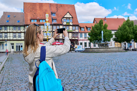 女旅游游客在历史建筑前 在一个旧欧洲城市拍摄相照的女游客景观冒充历史性手机地标正方形自拍电话照片女性图片