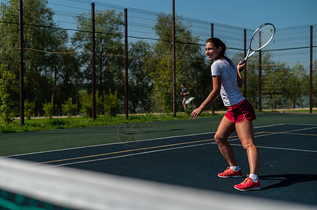 在炎热的夏季日 在户外法庭上打网球的年轻天主教女子晴天训练竞赛玩家专注运动员比赛活动网球假期图片