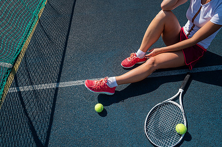 一个穿着运动裙的无脸女孩坐在网球场上 拿着一枚火箭 对女性腿最有洞察力运动玩家练习闲暇运动员游戏训练锻炼少年橡皮图片