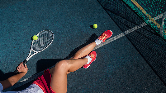 一个穿着运动裙的无脸女孩坐在网球场上 拿着一枚火箭练习女士运动晴天锻炼少年阴影球拍游戏行动图片