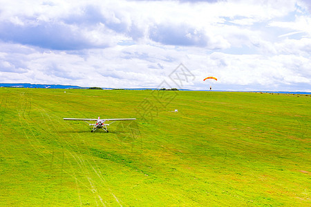 小飞机在绿地上 伞兵降落在绿地上图片