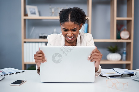 在现代办公室的笔记本电脑上沮丧 愤怒和压力重重的年轻女商务人士 女性在工作场所对技术表现出愤怒 女员工因连接速度慢而抢电脑图片