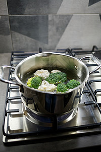 花椰菜和花椰菜在煤气炉子上的灰色酱锅里沸腾盘子餐具平底锅火炉食品烹饪妈妈女性成人主妇图片