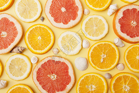 平面橙子 葡萄油和柠檬片 黄底有贝壳;夏季柑橘形态图片