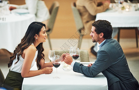 他们相处得很好 一对情侣亲切地手牵手 坐在餐厅的桌子上坐着呢图片