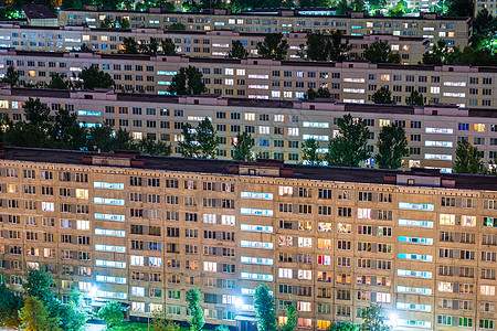 夜间城市的住宅区因公寓窗外灯光照亮而时间过晚间休息室的时间图片