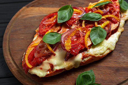平面披萨 在黑色木制背景的带蔬菜的扁面包上的披萨图片