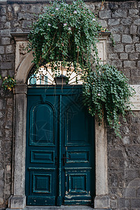 古老的木制门在旧石雕城堡墙中 欧洲城镇一条街上一栋美丽的旧建筑的前门和外部图片