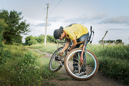 竹林小道乡下修自行车的人 路上修自行车的旅行者 路中间修自行车的人维修修理齿轮运输男人救援行车检查旅行车轮背景
