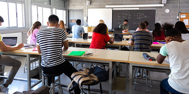 在教师评分考试期间 利用笔记本电脑对班级中多种族学生群体进行深视图片