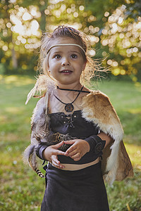 穿着原始人衣服的可爱宝宝节日森林羽毛日落公园护身符孩子婴儿乐趣毛皮图片