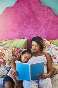 阅读为孩子的想象力带来光明 一位母亲在家里给她的小女儿讲故事图片