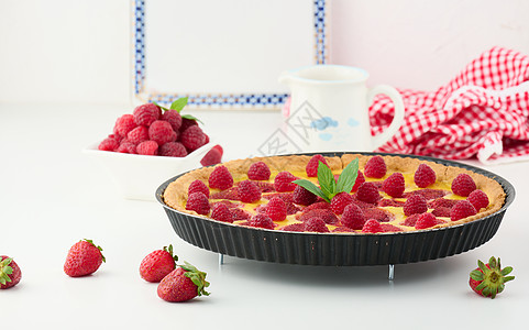 白桌上有红草莓和果的圆椰子糕点圆形美食家白色水果奶油桌子烹饪浆果红色图片