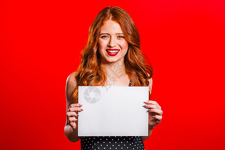穿着白色A4纸海报的漂亮女人 复制空间 时髦潮流女孩 工作室背景上印着红发图片