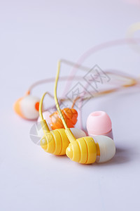 白色背景上多彩耳机的特写广告粉色网络技术橙子学习展示黄色屏幕教育背景图片
